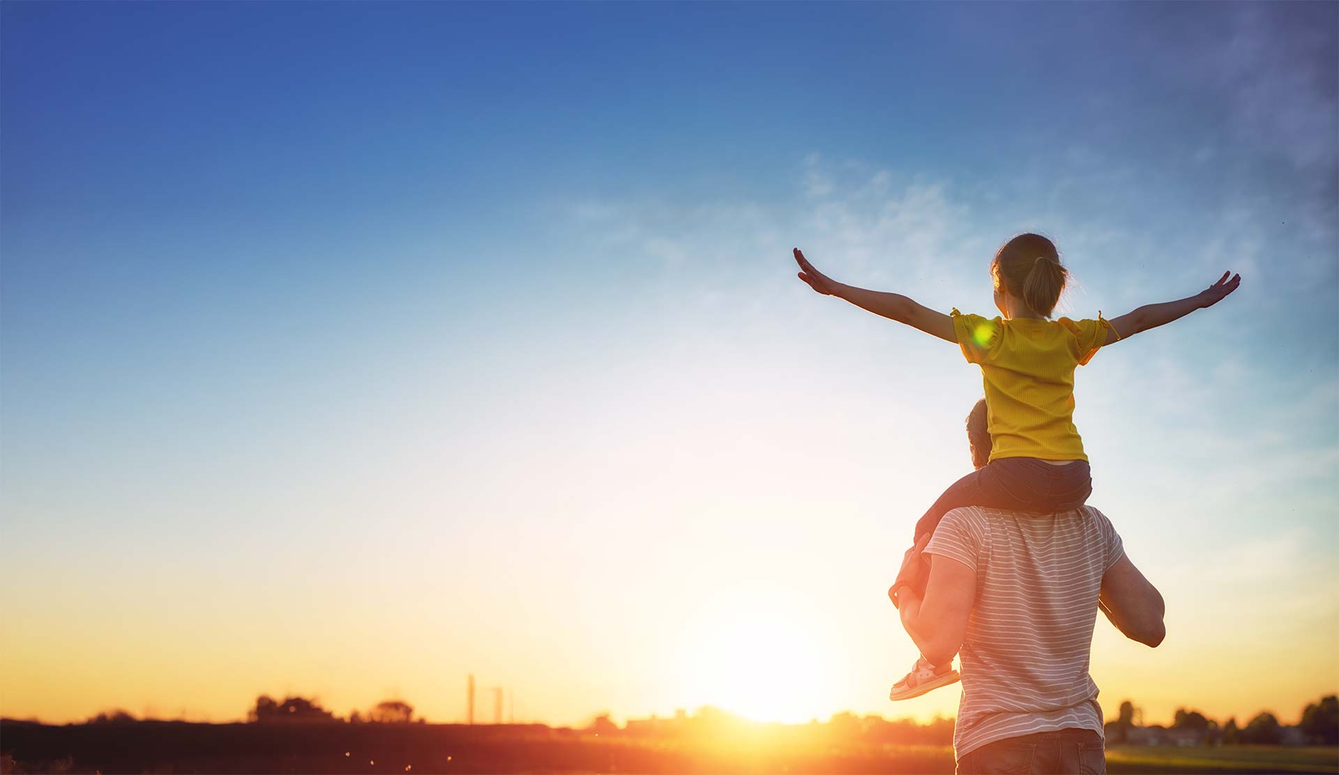 child sitting on adults shoulders